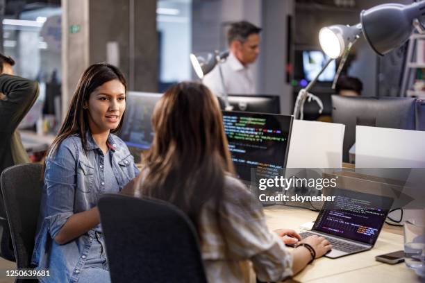 jonge vrouwelijke programmeurs die in het bureau spreken. - woman coding stockfoto's en -beelden