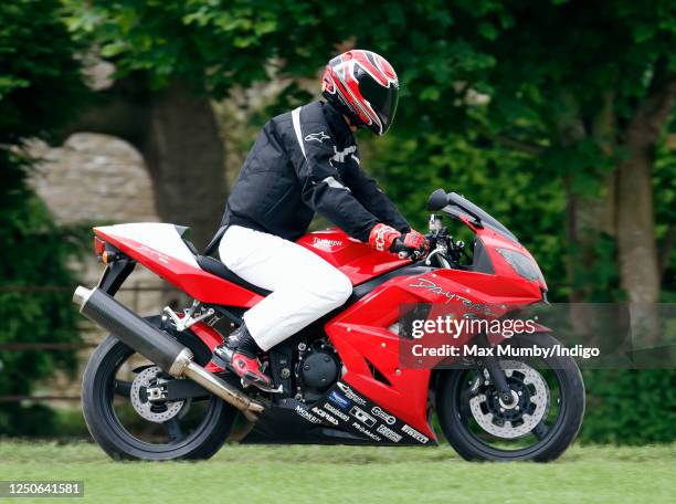 Prince William arrives, riding his Triumph Daytona 600 motorbike, to play in the Burberry Cup polo match at Cirencester Park Polo Club on June 17,...