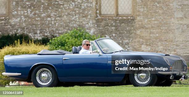 Prince Charles, Prince of Wales accompanied by Camilla, Duchess of Cornwall arrives, driving his 1969 Aston Martin DB6 Volante, to play in the...