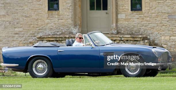 Prince Charles, Prince of Wales accompanied by Camilla, Duchess of Cornwall arrives, driving his 1969 Aston Martin DB6 Volante, to play in the...