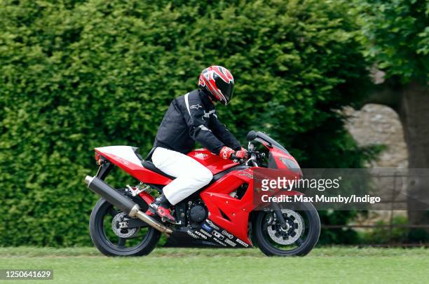 Prince William arrives, riding his Triumph Daytona 600 motorbike, to play in the Burberry Cup polo match at Cirencester Park Polo Club on June 17,...