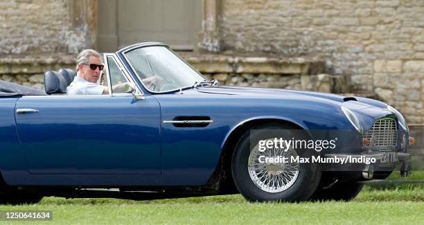 Prince Charles, Prince of Wales accompanied by Camilla, Duchess of Cornwall arrives, driving his 1969 Aston Martin DB6 Volante, to play in the...