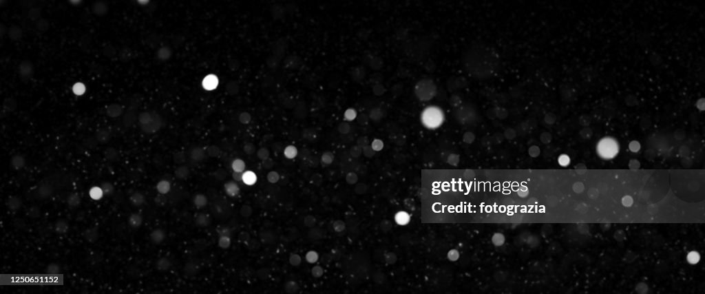 Defocused Lights and Dust Particles over Black Background
