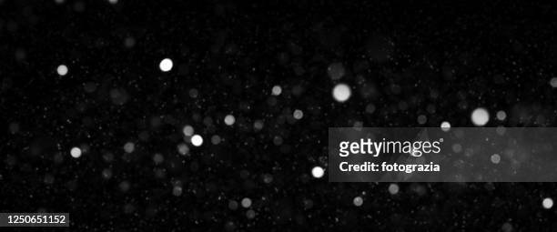 defocused lights and dust particles over black background - black and white christmas imagens e fotografias de stock