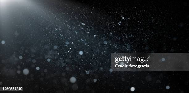 dust particles, sparkles and light rays over black background - lichteffect stockfoto's en -beelden