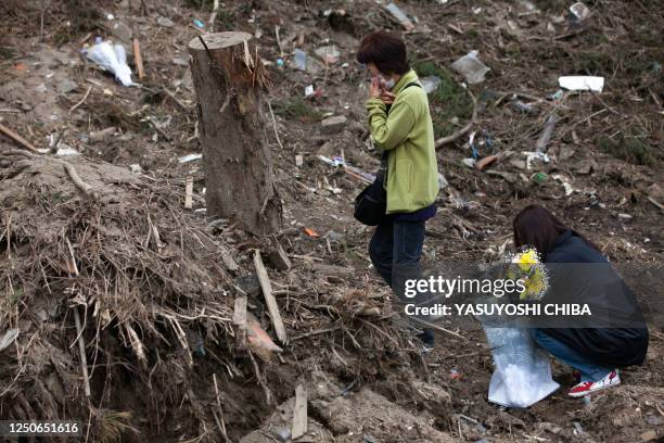 Month after the tsunami divastation, parents, family members who lost their children at the Okawa Elementary School offer flowers at the place where...