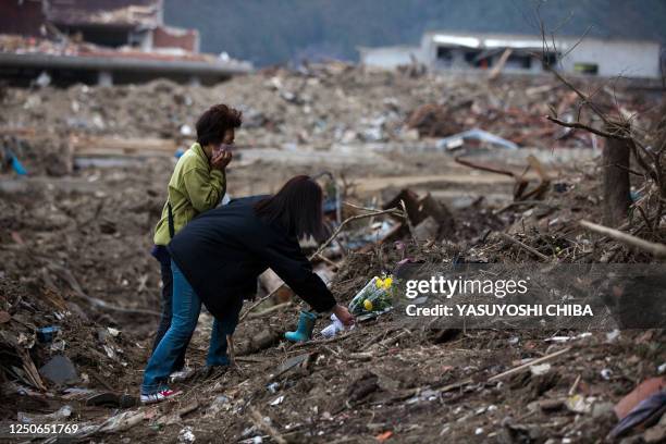 Month after the tsunami divastation, family members who lost their children at the Okawa Elementary School offer flowers at the place where many...