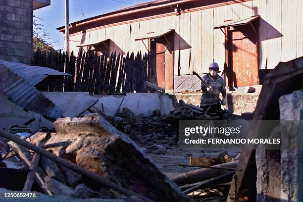 Man removes debris 20 February 2001 of a destroyed house in San Miguel Tepezonte, 35 km south fo San Salvador, El Salvador. Un hombre remueve...