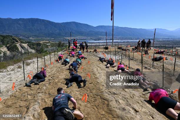 Competitors take part in "Tough Mudder" at the Glen Helen Raceway in San Bernardino, California, United States on April 2, 2023. Tough Mudder is an...