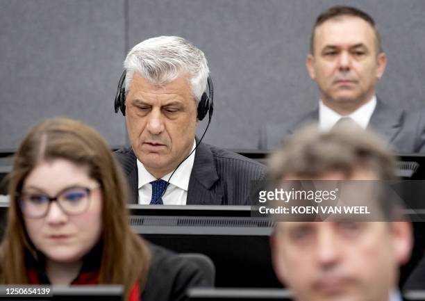 Former Kosovo president Hashim Thaci sits in court, near former KLA figure Rexhep Selimi , as he appears on charges of war crimes before the Kosovo...