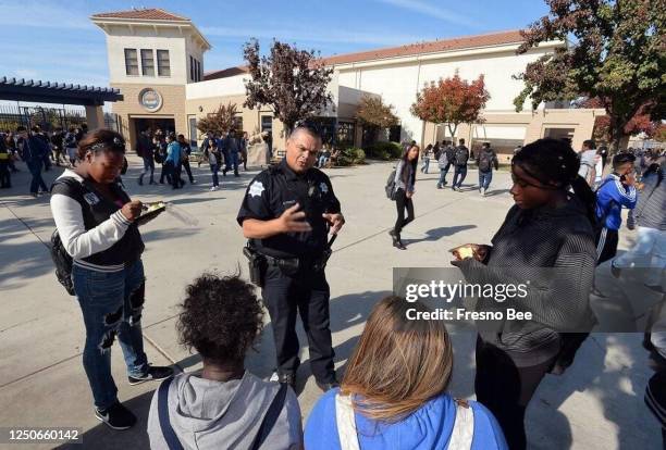 Student Resource Officer Roland Diaz speaks with a group of students during lunch at Sunnyside High School in Fresno.