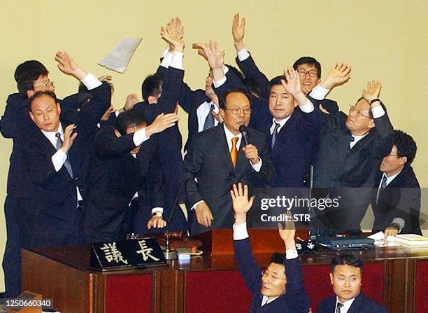 South Korea's parliamentary security guards surround Speaker Park Kwan-Yong as he announces the National Assembly's vote results of 193 votes to two...