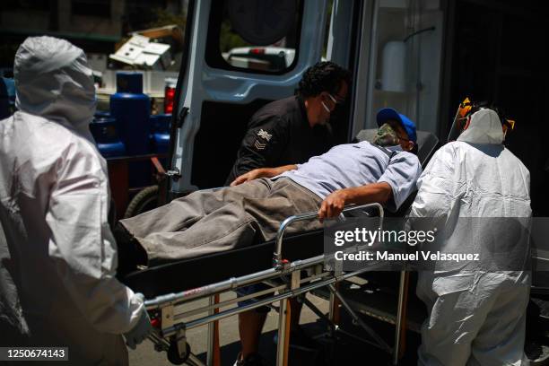 Paramedics of Nezahualcoyotl, transports a patient with probable COVID-19 to an ambulance to be taken to a hospital during the answer to an emergency...