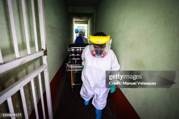 Antonia, paramedic of Nezahualcoyotl, transports a patient with probable COVID-19 to an ambulance to be taken to a hospital during the answer to an...