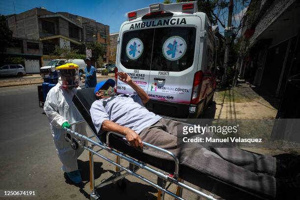 Man, probable COVID-19, waves goodbye to his wife as Antonia, paramedic of Nezahualcoyotl transports him to an ambulance to be taken to a hospital...