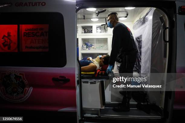 Paramedic of Nezahualcoyotl descends a patient from the ambulance to a hospital during the answer to an emergency call on June 18, 2020 in...