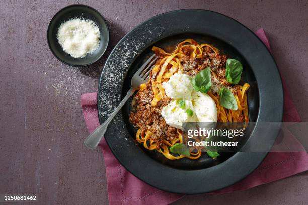 rich fettuccini bolognese with buffalo mozzarella - black plate stock pictures, royalty-free photos & images