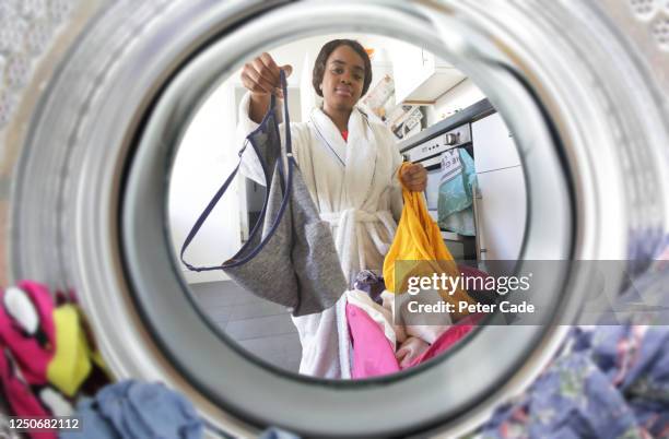 young woman loading the washing machine - funny laundry stock pictures, royalty-free photos & images