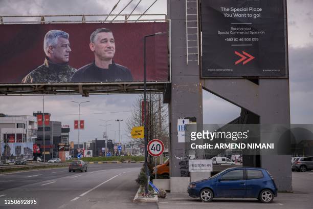 Giant banner depicting former Kosovan President Hashim Thaci and former Parliament speaker Kadri Veseli is displayed in Pristina on April 3, 2023. -...