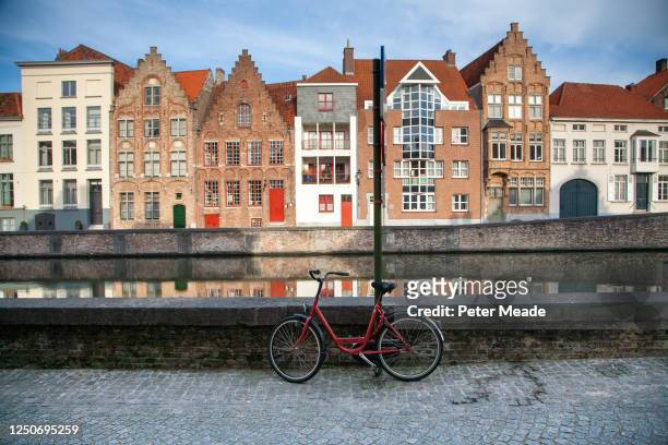 bicycle parked by a canal in bruges - belgium canal stockfoto's en -beelden