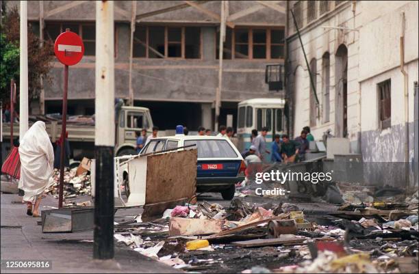 Veiled woman passes by rubble in Algiers 12 October 1988 following a week of unrest in most cities and as President Chadli Benjedid announced a...