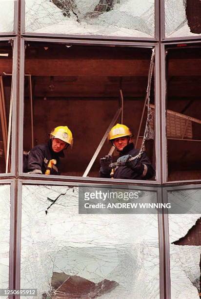 Two firemen work 11 February on one of the buildings devastated by the 09 February's IRA bombing in London's Dockland's area. - Two dead bodies were...