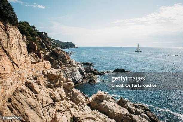 landscape with rock cliffs and sailboat in the sea - barcelona beach stock pictures, royalty-free photos & images