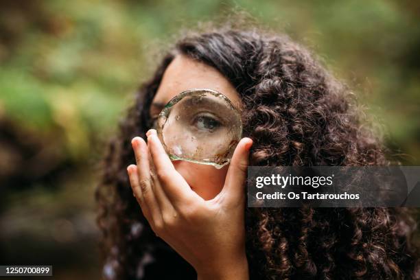 curly girl looking through tha glass of a bottle bottom - crimped hair imagens e fotografias de stock