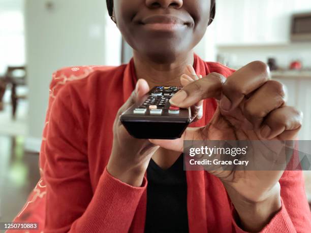 woman watches tv - changing channels stockfoto's en -beelden