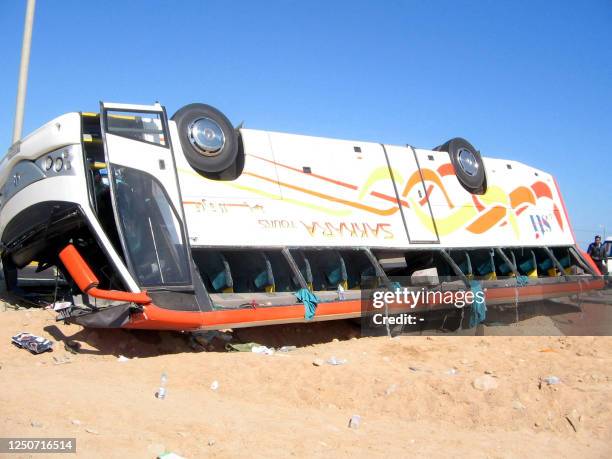 An overturned tourist bus lies in the desert in Hurghada 31 January 2006, after the bus spun off the coastal road along the Red Sea, killing fourteen...