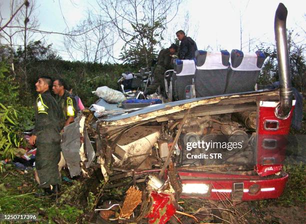 Agentes de la Policía de Carreteras colombiana examinan los restos de un autobús accidentado el 16 de enero de 2004, en sector de Sabana de Torres,...