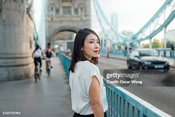 successful and cheerful businesswoman in the city - japanese bussiness woman looking up stock-fotos und bilder