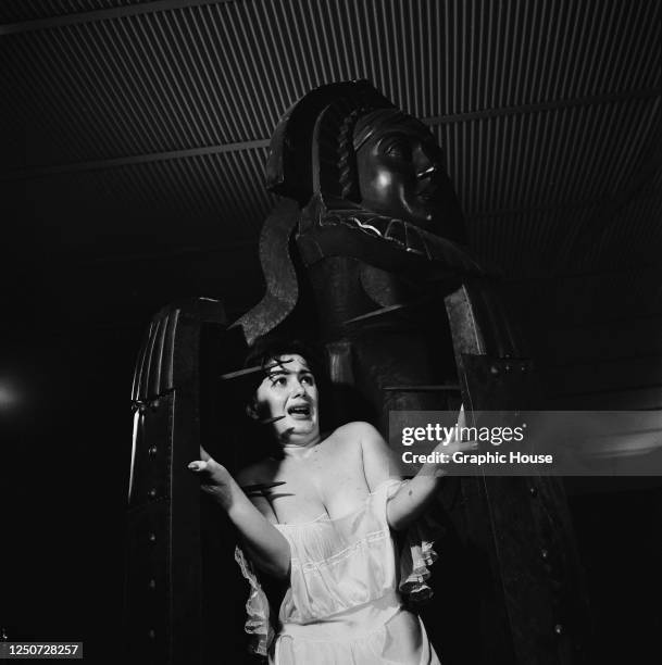 Young woman cowers inside an iron maiden, circa 1960.