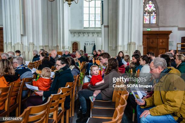 People are seen listening to the reverend during a short religious story inside the church. As part of the 750th anniversary of the Sint Stevenskerk...