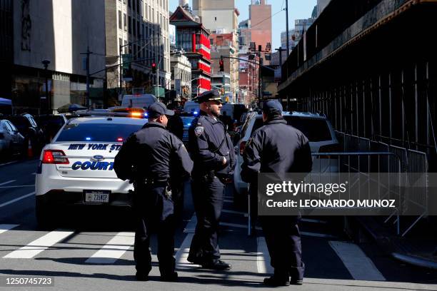 New York police officers provide security outside the Manhattan District Attorney's office in New York City on April 3, 2023. - Donald Trump is...