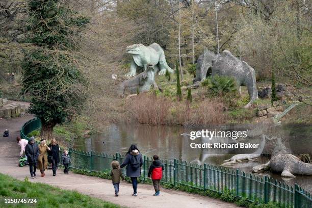 Visitors admire the Victorian-era Grade I-listed dinosaur sculptures in Crystal Palace Park, on 3rd April 2023, in London, England. Crystal Palace...