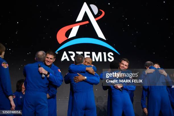 Astronauts Jeremy Hansen, Victor Glover, Reid Wiseman and Christina Hammock Koch hug fellow astronauts after being selected for the Artemis II...