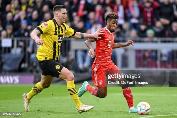 Niklas Suele of Borussia Dortmund and Kingsley Coman of Bayern Muenchen battle for the ball during the Bundesliga match between FC Bayern München and...