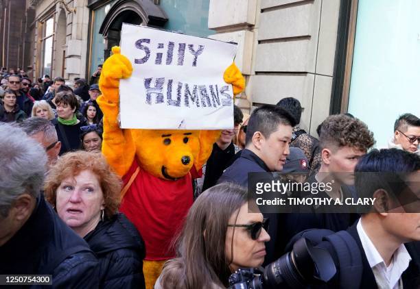 Person dressed as Winnie the Pooh walks down 5th Avenue in front of Trump Tower in New York on April 3, 2023 as crowds wait for former US president...