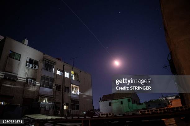 Flares of syrian air defense rockets are seen in the sky of Damascus on April 3, 2023. Two Syrian civilians were killed in an Israeli air strike,...