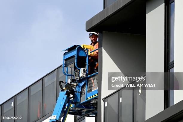 Men work on a construction site, building new apartments in Melbourne on April 4, 2023. - The Reserve Bank of Australia held interest rates after ten...