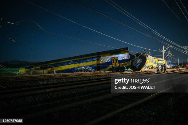 Emergency services work on the site of a derailed train in Voorschoten, on April 4, 2023. The passenger train collided with construction equipment on...