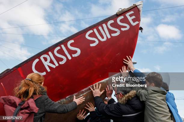 Protestors hold a boat reading 'Crisis Suisse' during a demonstration outside the Credit Suisse Group AG annual general meeting of shareholders in...
