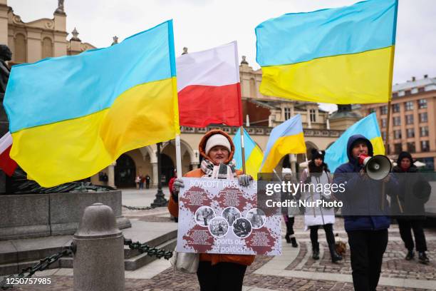 Woman holds a banner calling to ban Russian and Belarusian athletes from the Paris 2024 Summer Olympics while attending a demonstration of solidarity...