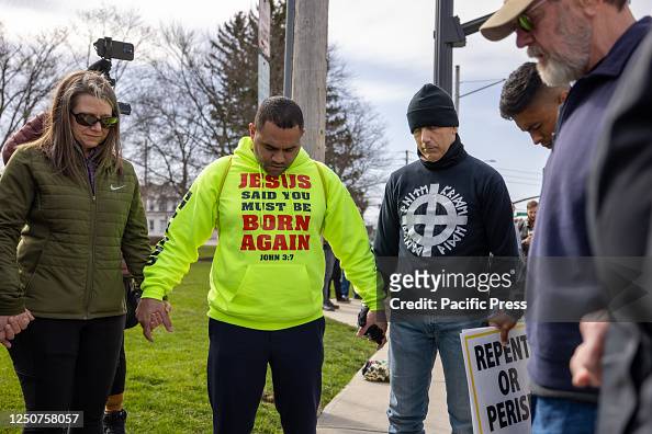 A group of Christian protesters prays together across the...