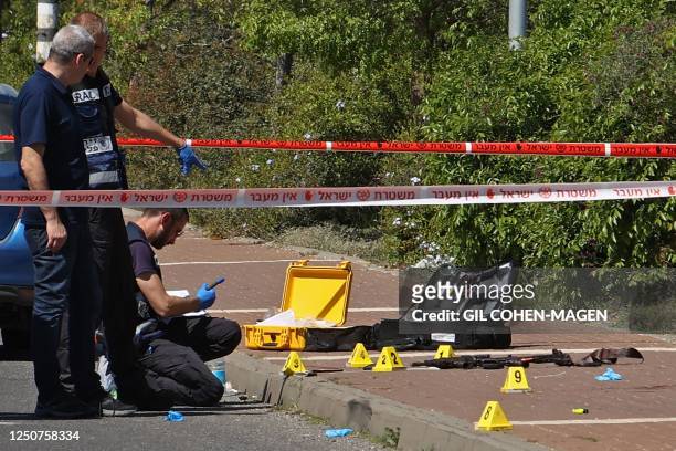Israeli forensic experts inspect the scene of a stabbing attack near Tzrifin military base on the outskirts of Tel Aviv, on April 4, 2023. - Two...