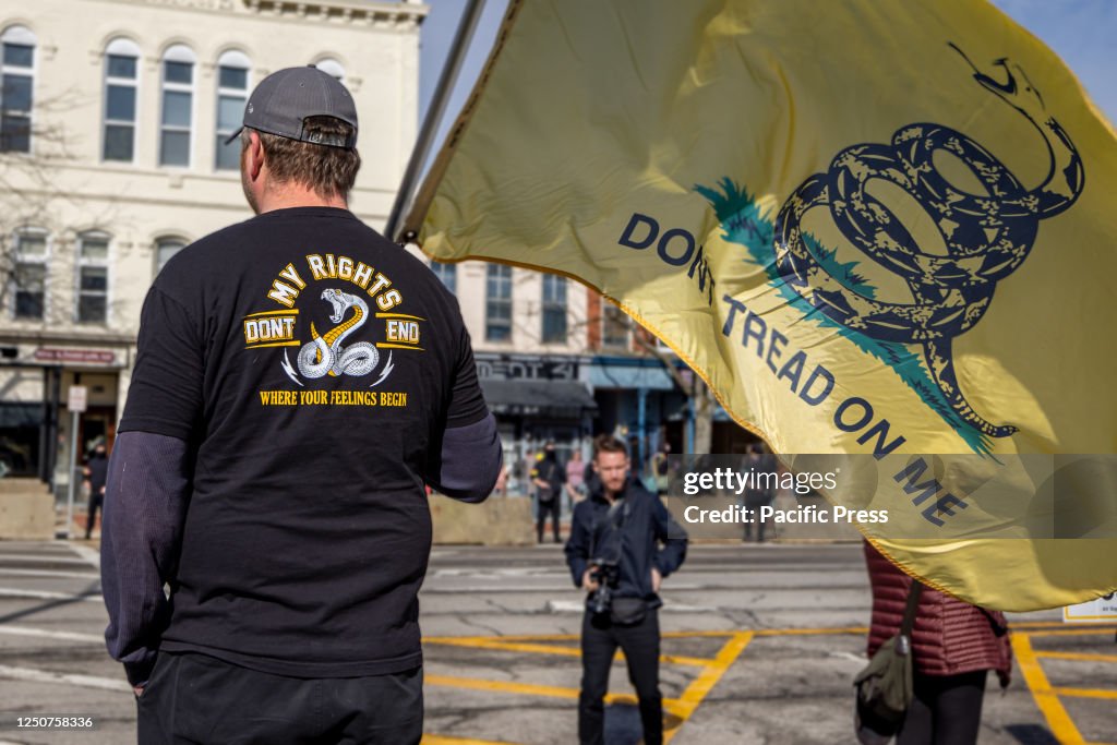A man with Gadsden flag protests outside Element 41, a...
