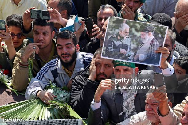 Man holds a sign depicting slain Iranian military commander Qasem Soleimani and late founder of the Islamic Republic Ayatollah Ruhollah Khomeini...