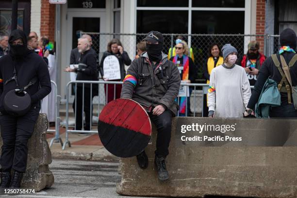 An anti-fascist holding a shield guards the entrance of Element 41, a restaurant holding an 18 and over drag brunch to raise money for a local...