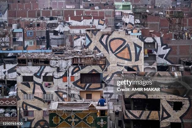 This picture taken on February 9, 2023 shows graffiti work by Tunisian street-artist El Seed in the Zabalin area of Cairo. - The graffiti is a part...